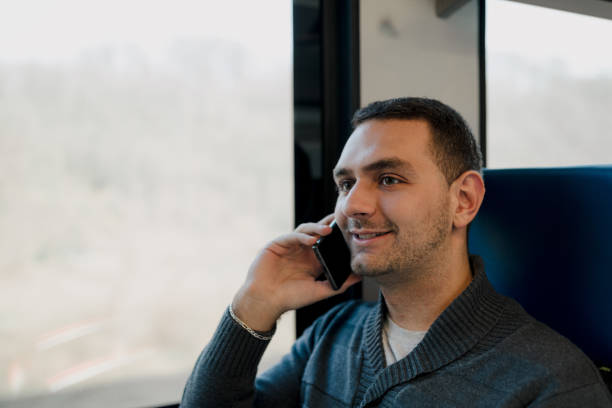 istock Young Man Using Smartphone While Traveling on Train for Business 2190586487