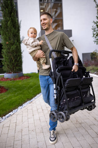 istock Father carrying his young child and stroller 2190588466