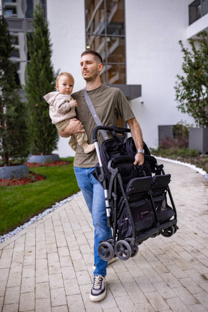 istock Dad cradling his baby while expertly handling a stroller 2190588860