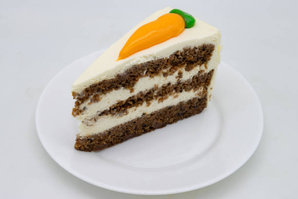 Round carrot cake showing sponge layers and white cream cheese frosting on a dark plate