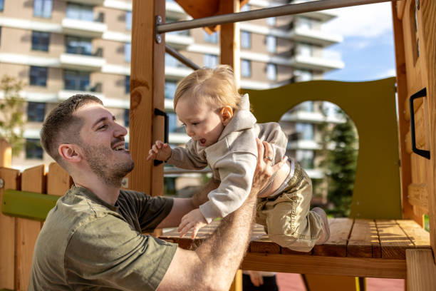 istock Father and Son Enjoying a Sunny Day on the Playground 2190593597