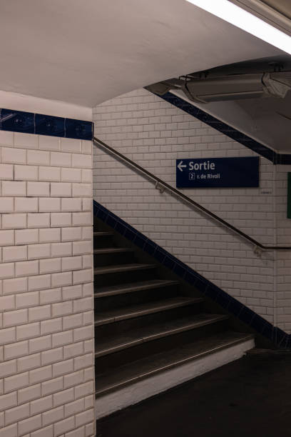 istock Exit from the Paris metro. Sign: Exit and street name. Steps and a tiled walkway with a low ceiling 2190597110