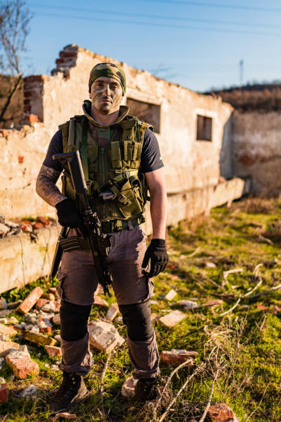 istock Armed Soldier in Tactical Gear Standing in an ruined building 2190597601