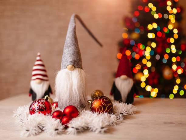 istock Festive Christmas Gnome Decorations with Ornaments and Bokeh Christmas Tree in Background 2190598281