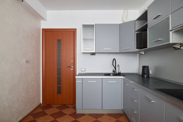 This modern kitchen features elegant gray cabinets and a stylish door that reflects contemporary design