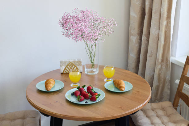 A Beautifully Set Bright Breakfast Table Featuring Delicious Croissants and Fresh Strawberries