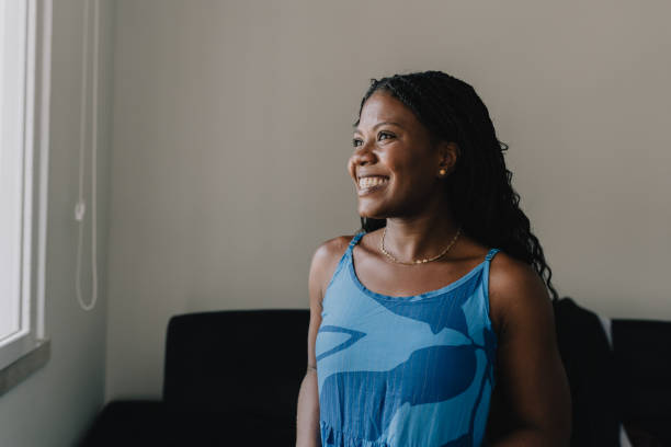 istock Smiling woman by the window in natural light 2190603365