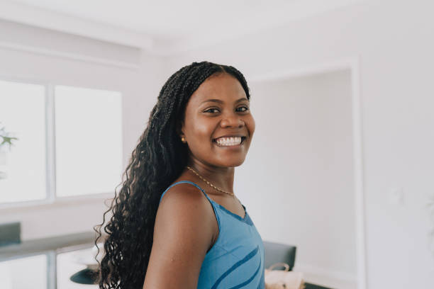 istock Smiling young woman standing in bright living room 2190603367