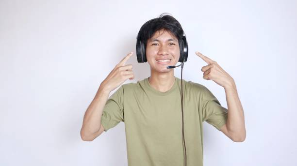 istock Asian man gesturing excitedly happy using earphones on white background 2190604385