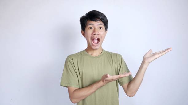 istock Shocked young Asian man pointing to the left side 2190605002