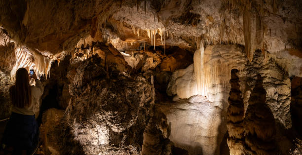 Spectacular underground limestone rock formations, lit up by lights, inside the a limestone cave system