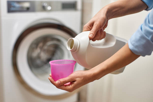 istock Woman pours liquid laundry detergent into plastic cap 2190606142