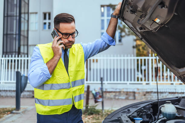 istock Man in Safety Vest Calling for Roadside Assistance 2190606548