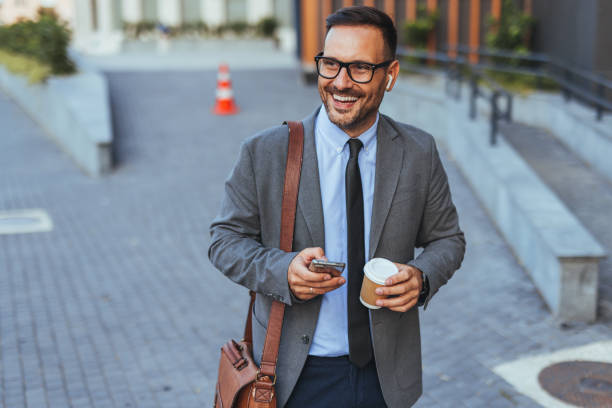 istock Confident Businessman Walking with Coffee and Smartphone 2190606568