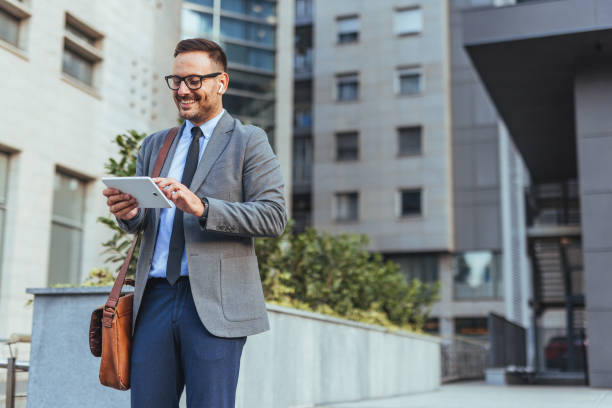 istock Businessman Using Tablet in Urban Environment with Headphones 2190606569
