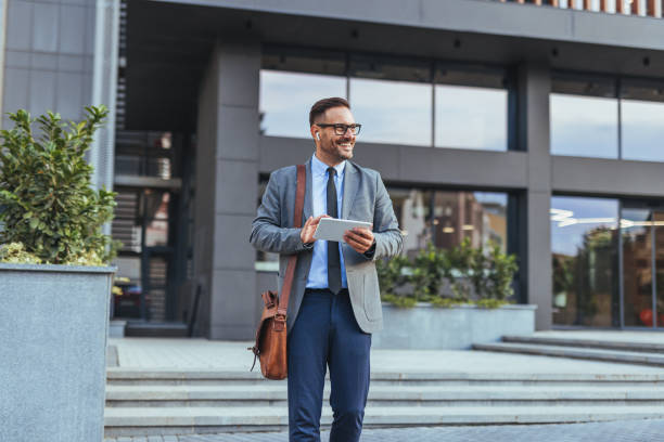 istock Modern Businessman Holding Tablet Outside Office Building 2190606570