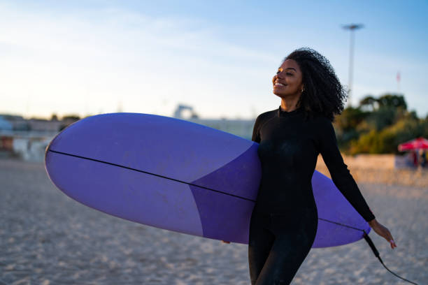 istock Joyful Black Female Surfer with Surfboard on Beach 2190607284