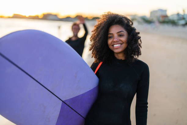 istock African American Female Surfer with Board on Beach 2190607297