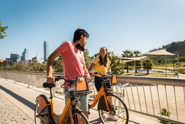 istock Friends walking carrying bikes and talking on the public park 2190608695
