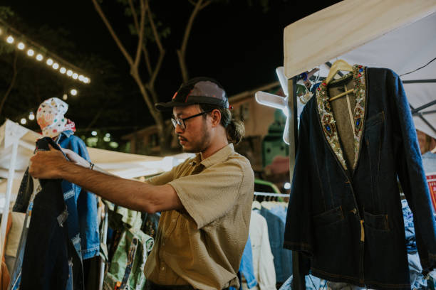 istock Hipster Asian man is choosing a second hand jacket for himself. 2190611569