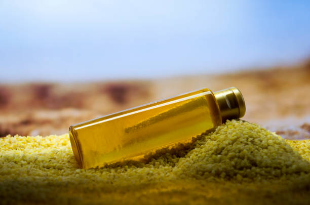 Gold unbranded cosmetic bottle mockup on desert background.