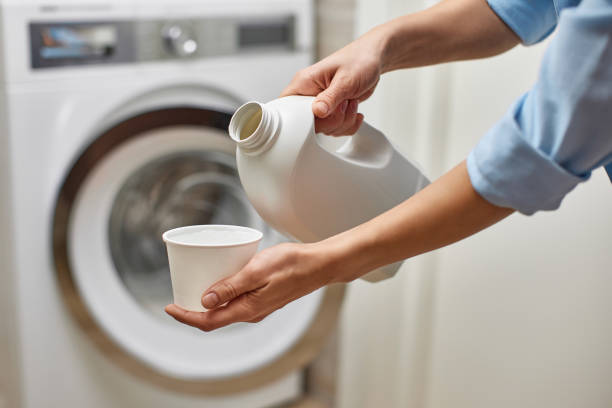 istock Woman pours liquid laundry detergent into plastic cap 2190616347