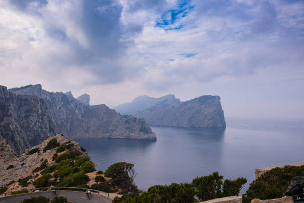 High cliffs jutting out far into the sea. Beautiful seascape. Calm blue sea and clear sky above huge cliffs.
