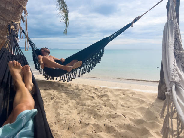 istock Relaxed Man Lounging in Hammock on Tropical Beach 2190620317