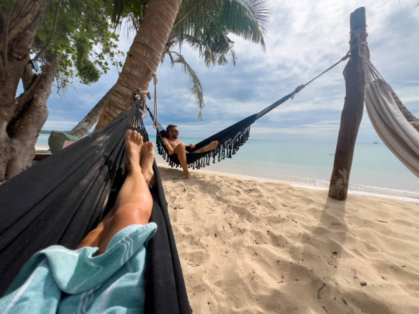 istock Relaxed Man Lounging in Hammock on Tropical Beach 2190620322