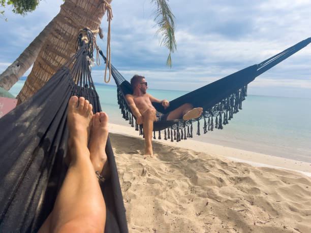 istock Relaxed Man Lounging in Hammock on Tropical Beach 2190620323