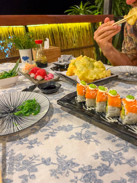Person Dining at Outdoor Restaurant with Sushi and Tempura