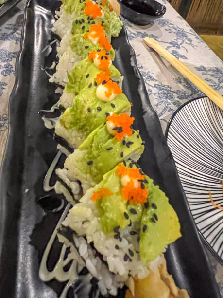 Avocado Topped Sushi Roll with Roe and Sesame Seeds