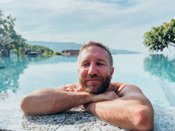 istock Man Relaxing in Infinity Pool with Scenic Mountain View 2190620456