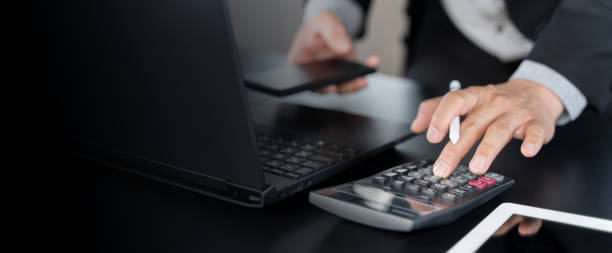 Business accounting concept, Business man using calculator with computer laptop, budget and loan paper in office.
