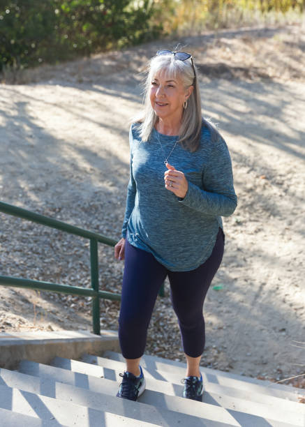 Senior woman walking up outdoor steps for exercise