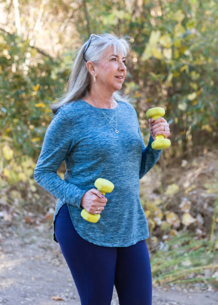 istock Senior woman walking with hand weights on a path 2190624193