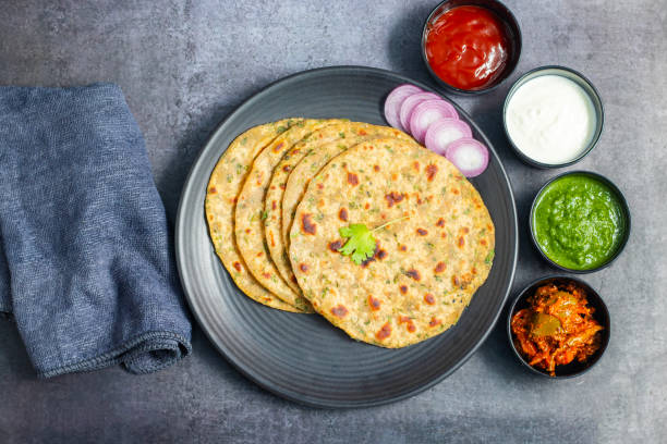 istock Palak paratha is a soft, spinach-filled flatbread, served with creamy, spiced palak paneer—a flavourful spinach and cottage cheese curry. 2190629232