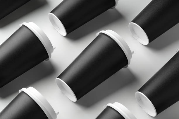Multiple black takeaway coffee cups arranged in a repeating pattern on a white surface