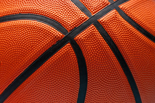 istock Orange basketball ball lit from above on blue background 2190636317