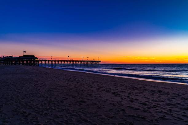 istock Serene beach sunset with pier and vibrant sky. 2190636869