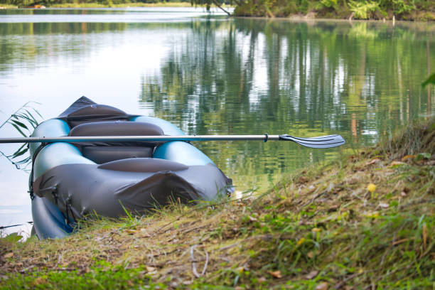 istock Inflatable kayak with paddle resting on serene lakeshore surrounded by lush green trees 2190638012