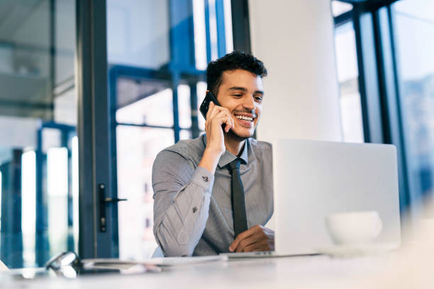 istock Young Professional in Modern Office Environment Using Laptop and Mobile Phone 2190639088