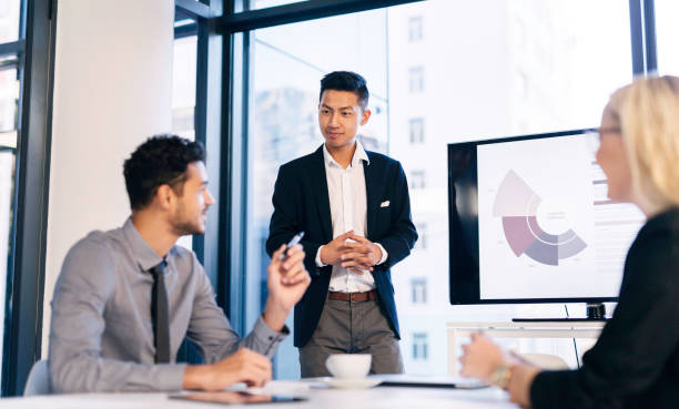istock Confident Business Professional Leading Presentation with Engaged Team in Modern Office Setting 2190639106