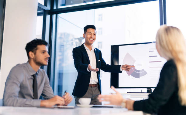 istock Young Professional Leading Meeting With Colleagues in Modern Office Setting 2190639111