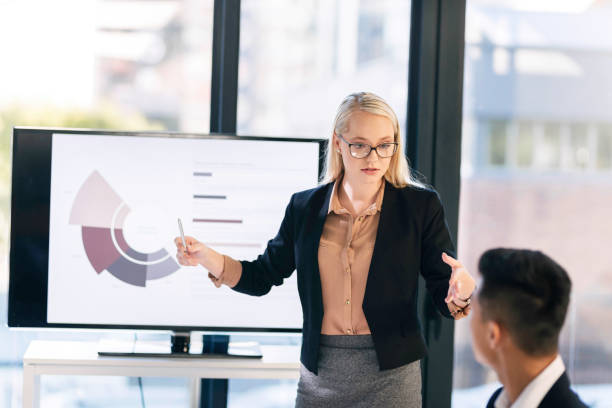 istock Confident Businesswoman Presenting Data Analysis in Modern Office Meeting 2190639121