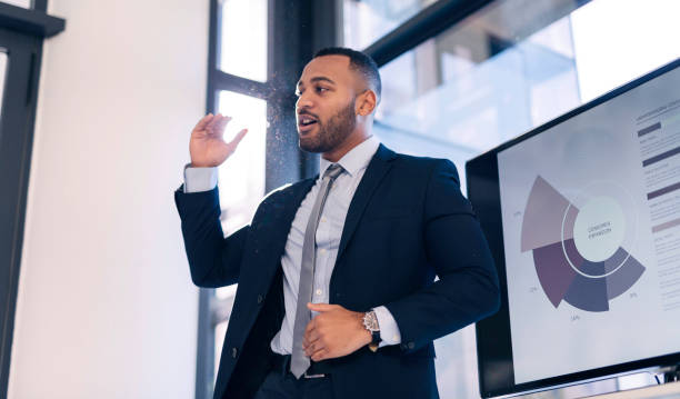 istock Confident Business Professional Giving a Powerful Presentation in a Modern Office with Graphical Display on Screen 2190639123