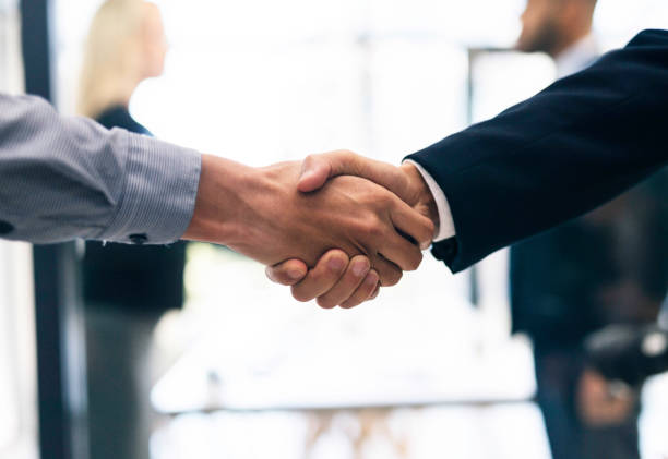 istock Business Handshake Between Colleagues in a Corporate Office Setting with Light Background 2190639138