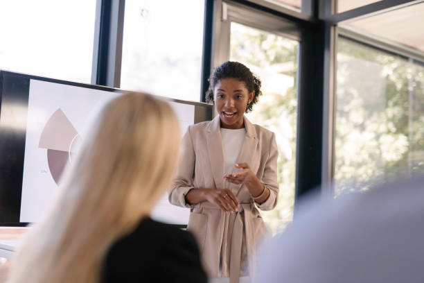 istock Young Professional Giving a Dynamic Presentation in a Modern Office Setting With Colleague in Focused Discussion 2190639139