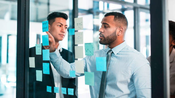 istock Business Professionals Collaborating on Strategy with Sticky Notes in a Modern Office Environment 2190640328