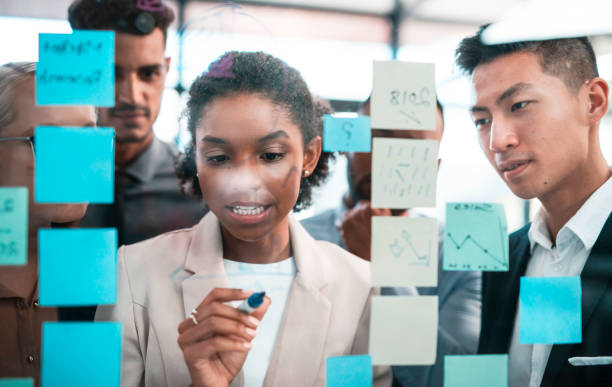 istock Diverse Team Collaborating on a Transparent Board with Sticky Notes in a Modern Office Setting 2190640361